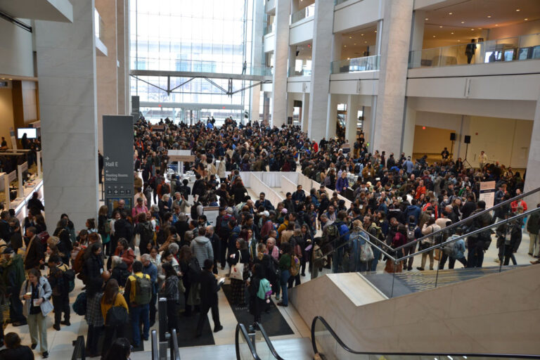 Hundreds of excited attendees gather in the Atrium of Huntington Center during AAG 2025 Detroit welcome reception