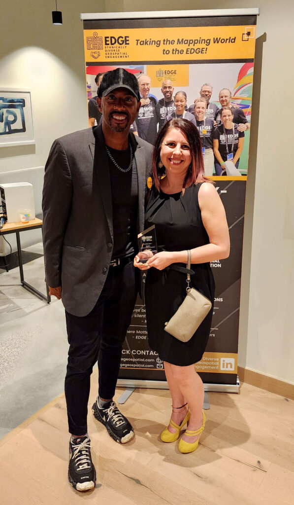 Keith Searles (left) presents the 2023 EDGE Award for Professional Organization to American Association of Geographers representative and Community Manager Emily Fekete (right). Credit: Kevin Freese