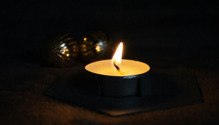 A small candle burnsin the midst of a dark background Credit: Dagmara Dombrovska, Unsplash