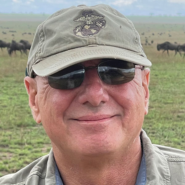 Photo of Mike DeVivo in a field with grazing horses